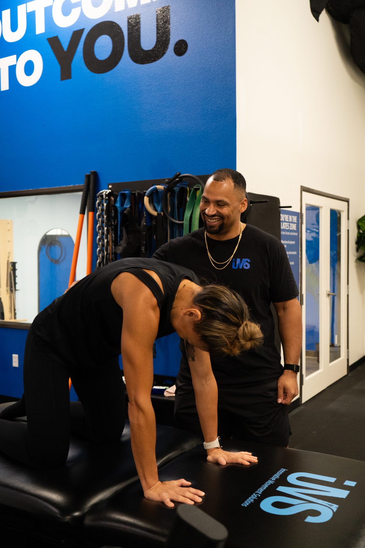 Jason coaching a client through a cat-cow spinal sequence at the IMS studio